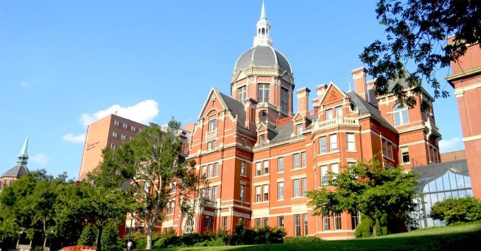Johns Hopkins red-brick domed building on a sunny campus lawn