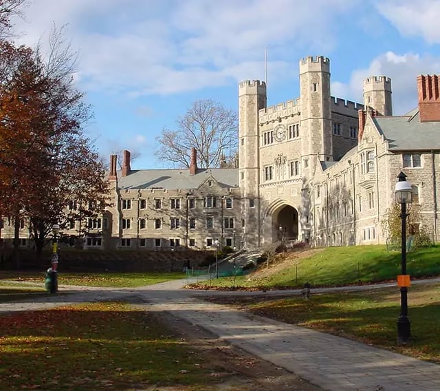 Princeton University Gothic stone building with towers and an archway on an autumn campus